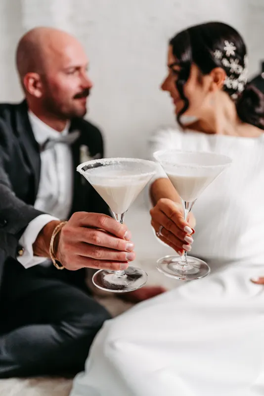 Brautpaar stößt mit Cocktails im Martiniglas an