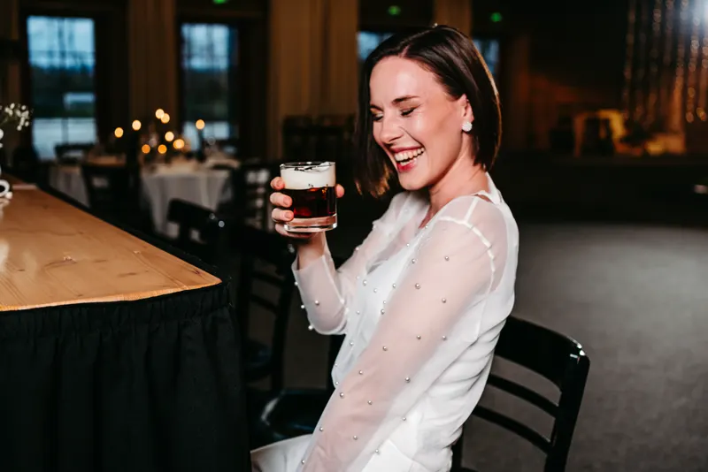 Lachender Gast mit einem Cocktail in der Hand