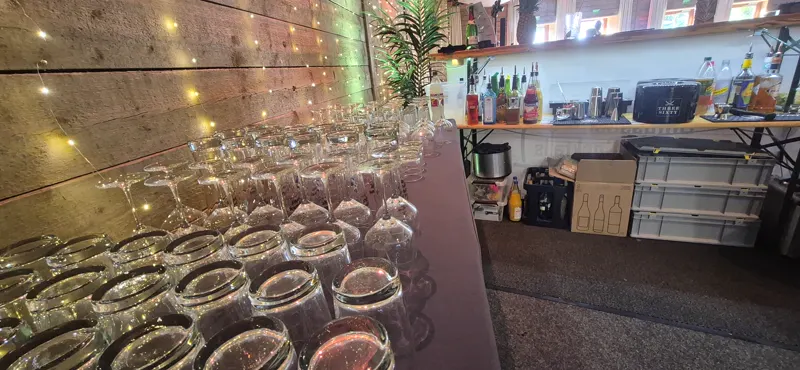 Reihen vorbereiteter Gläser an der Bar vor Beginn der Feier