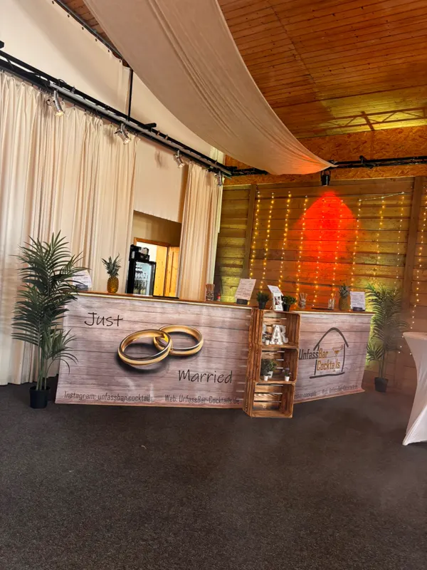 Mobile Bar mit „Just Married“-Verkleidung in einer festlich geschmückten Location