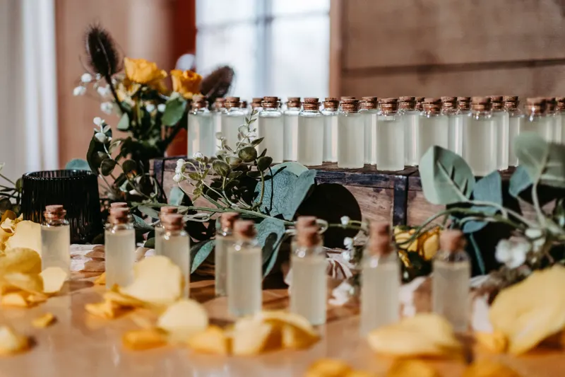 Viele kleine Shot-Fläschchen auf einem mit Blumen dekorierten Tisch